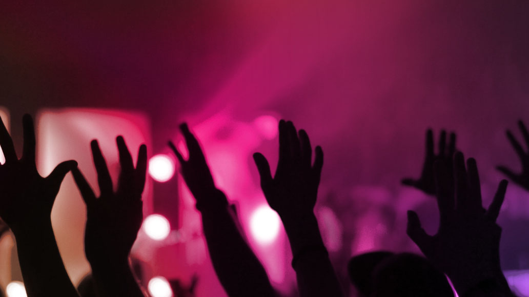 a bunch of hands up at a concert